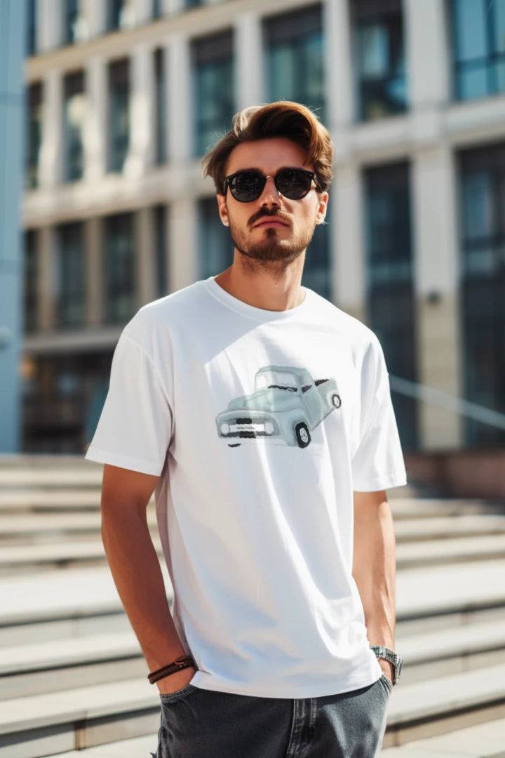 Man wearing a white t-shirt with a graphic design, standing outdoors.